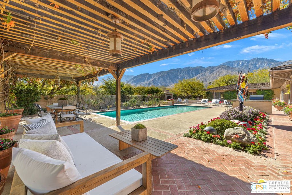 Discover a truly unique opportunity to own an exquisite Albert Frey-designed home in the heart of Smoke Tree Ranch! Built in the hacienda style, this home captures the essence of early California living, blending architectural charm with open, inviting spaces that make 1850 Smoke Tree Lane a must-see. Set on .73-acres with breathtaking south-facing views, this setting is perfect for outdoor gatherings, featuring inviting conversation areas, covered patios, pergolas, and a destination-style barbecue area. Relax by one of the welcoming fireplaces, both indoors and out, or delight in the surprise of a beautiful fruit orchard that adds to the home's allure. Step inside to a formal living and dining area that boasts unobstructed mountain views, complemented by striking beamed and vaulted ceilings, stunning tile work, and impeccable finishes throughout. The Chef's kitchen maintains the home's period aesthetic and offers an adjacent butler's pantry for added convenience. The Primary Suite offers seamless indoor-outdoor flow to the pool terrace, while the ensuite guest bedrooms provide sought-after privacy on the home's opposite end. Additionally, the rare climate controlled oversized four-car garage enhances the living experience. Take the Matterport virtual tour for a better sense of flow. Experience the magic of Smoke Tree Ranch, set on over 300 acres of serene beauty, and don't miss the chance to embrace a delightful desert lifestyle in this remarkable home!