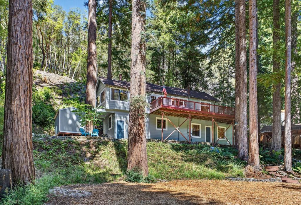 Welcome to 1480 Hillside Dr, a peaceful retreat in the private Bracken Brae community where you can enjoy exclusive trails and quiet river access. This 3 bedroom, 2 bath home welcomes you with a living room that features Brazilian cherry floors, an inviting wood burning stove, and sweeping redwood views. The bright, thoughtfully designed kitchen showcases quartz countertops and a suite of Bosch appliances, opening into a family room where wall to wall windows bring the forest right to you. Step out onto the spacious deck, perfect for family gatherings, entertaining friends, or simply relaxing in the fresh mountain air. Downstairs offers a private bedroom and bath along with a versatile bonus room that works beautifully as an office, playroom, or guest space. Central heating keeps you comfortable year round while the flexible layout gives you room to make it your own. With oversized parking for a boat or RV, a carport, and two sheds for extra space, this home has all the room you need for both everyday living and outdoor adventures. Just minutes from downtown Boulder Creek and a short drive to Big Basin, this home is a true blend of comfort, nature, and community.
