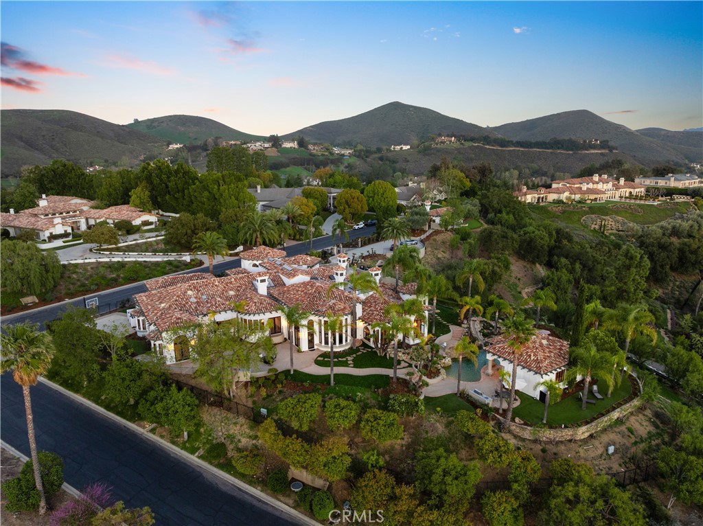 This breathtaking property is a true masterpiece of luxury and design! A gated Spanish contemporary compound in the exclusive North Ranch Country Club Estates, it combines traditional elegance with modern sophistication. Reimagined by designer Robb Friedman, the home offers unparalleled craftsmanship, panoramic mountain views, and lavish amenities.
Key Features:
• Interior Highlights:
• Gourmet Kitchen: Custom cabinetry, dual Viking refrigerators, 66-inch Viking Tuscany range, two dishwashers, and a butler’s pantry.
• Entertainment: State-of-the-art theater, game room, and dual powder rooms.
• Luxurious Primary Suite: Includes a sitting room, cement fireplace, European white oak/glass walk-in closet, a spa-like bathroom with a cement soaking tub, custom shower, and a massage/yoga room.
• High-End Finishes: Moroccan lime-wash accent walls, custom European wide-plank white oak flooring, and designer bathrooms.
• Resort-Style Grounds:
• Two pools: One with a waterfall and pool house, the other with waterslides and a grotto.
• Multiple outdoor entertaining spaces: Two BBQ areas, a gazebo, and sprawling lawns.
• Scenic exploration: Custom rock staircases spanning 3+ acres of grounds with jetliner views.
• Additional Luxuries:
• Elevator and dumbwaiter for convenience.
• Detached guest house and pool house.
• Oversized 4-car garage with storage.
• Oversized Solar Power System.
Every detail of this estate is meticulously curated for beauty and functionality, making it a rare gem in the luxury market.