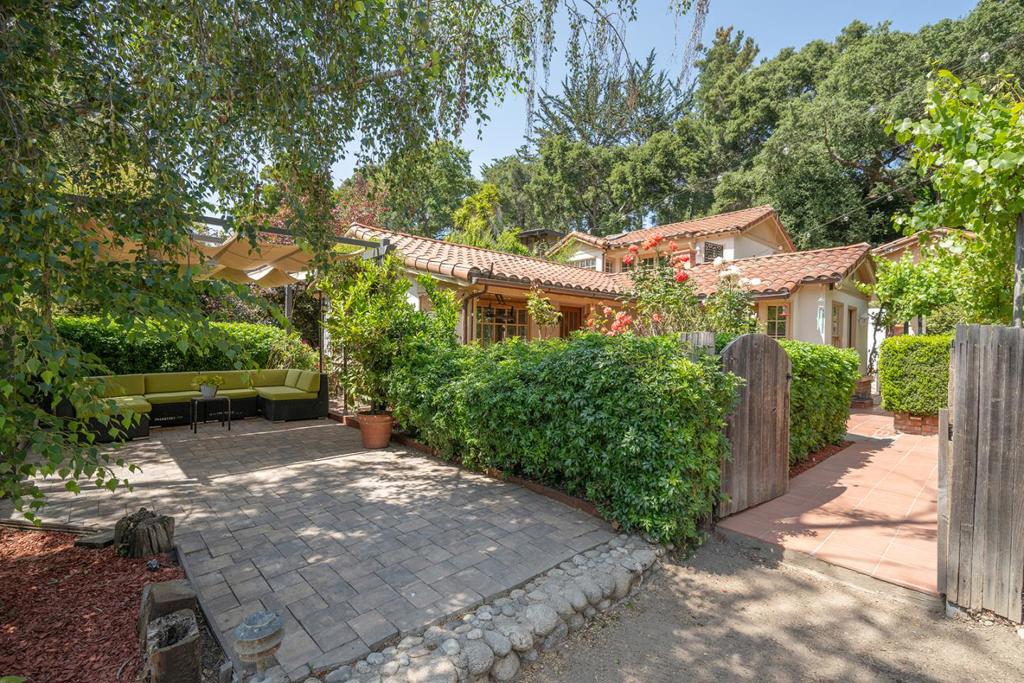This lovely Mediterranean inspired home is situated in a serene Carmel Valley neighborhood, just moments from Garland Park, the Carmel River, Tularcitos School, and the village. Set on over a quarter-acre, the approximately 1,446 sq. ft. main house features two bedrooms, two bathrooms, hardwood floors, and two indoor fireplaces. The primary bedroom includes a private balcony with beautiful mountain views. A detached guest house studio adds approximately 360 sq. ft. of additional living space and includes its own bathroom ideal for visitors or a private studio. The property boasts multiple outdoor patios, an outdoor fireplace, three outdoor sheds, established fruit trees, and an enchanting garden. This home combines comfort, charm, and an unbeatable location to offer the best of Carmel Valley living.