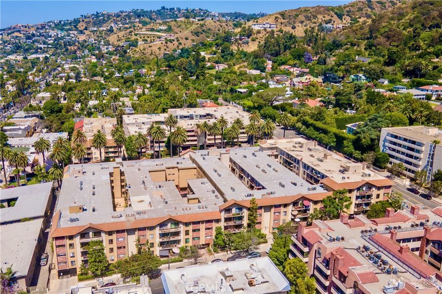 This beautifully reimagined top-floor one-bedroom condo offers 831 square feet of refined living in a prime Hollywood Hills location, just moments from Runyon Canyon and the Sunset Strip. East-facing and filled with natural light, the residence has been thoughtfully updated to blend comfort, design, and high-end finishes throughout. Light-toned oak-style floors, custom millwork, and trimless LED lighting are enhanced by WiFi-enabled Lutron smart switches for seamless ambiance control. The kitchen is both stylish and functional, featuring custom soft-close cabinetry, quartzite counters, handcrafted tile, a Bosch paneled dishwasher, and GE smart appliances—including a range and a refrigerator with built-in ice maker. The sunlit dining area is anchored by elegant drapery and a decorative stone fireplace that adds warmth and architectural interest. The spa-inspired bathroom is appointed with a marble countertop, Moen fixtures, a Kohler soaking tub, and a separate glass-enclosed shower clad in dramatic herringbone tile. The spacious bedroom offers abundant natural light and a walk-in closet, while a large hall closet provides additional storage. The pet-friendly building offers a full suite of amenities, including a gym, sauna, rec room, barbecue area, media lounge, and a fully renovated pool and hot tub coming soon. A new elevator provides access from the secure garage, where two tandem parking spaces are included. Set near the best of Hollywood and West Hollywood, this designer retreat offers turnkey living in one of LA’s most vibrant neighborhoods.
