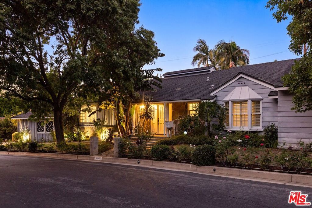 A sophisticated take on the classic Mid-Century California Ranch, this beautifully reimagined home offers the ultimate in relaxed, refined living. Perfectly situated on a lush, private lot South of the Boulevard in the foothills of Studio City, it combines timeless design with modern luxury. From the moment you arrive, the home captivates with impeccable curb appeal - manicured landscaping, mature greenery, and a welcoming facade set the tone for what's inside. Step through the front door into an open-concept interior filled with natural light, warm wood flooring, and designer touches throughout. The heart of the home is a gourmet eat-in kitchen featuring top-of-the-line stainless steel appliances, a 6-burner Viking range, wine fridge, and seamless flow into both the breakfast and dining area, ideal for entertaining and family gatherings. French doors throughout blur the line between indoor and outdoor living, opening to a stunning, private backyard with a flagstone patio, perfect for dining under the stars or enjoying Southern California's year-round sunshine. This 4-bedroom, 4-bathroom residence includes luxuriously remodeled marble bathrooms with premium finishes, fixtures, and lighting. Every detail has been thoughtfully curated to enhance comfort, style, and functionality. Nestled just minutes from major studios (NBC, CBS, Warner Bros., Disney, Universal), the Hollywood Bowl, and the trendy boutiques and restaurants along Ventura Boulevard, this is more than a home - it's a lifestyle. Welcome to your private retreat in the heart of Studio City.