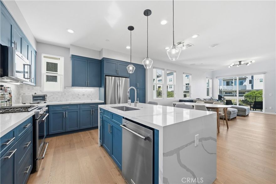 Beautifully upgraded 2 bedroom, 2.5 bathroom light and bright end unit, with quartz waterfall counter tops, home automation including blinds on third story, upgraded engineered wood flooring and Paid Off Solar! Designer interior paint, and elegant glass railings and surround sound that enhance the home’s modern aesthetic. The gourmet kitchen features a dual waterfall-edge quartz countertop, upgraded pull-out drawers, and premium finishes that make it a true showpiece. The downstairs bedroom and full bathroom with direct two car garage access, are ideal for guests or a home office. Upstairs, you’ll find a versatile loft with bonus space off the bedroom, perfect for a playroom, media area, nursery or private retreat. The automated window blinds on the third story offer both convenience and sophistication. Every detail has been thoughtfully designed to exceed model-home quality—this home is truly better than the model in one of San Diego’s most sought-after master-planned communities - 3 Roots. This modern residence offers the perfect blend of luxury, comfort, and energy efficiency. Enjoy resort-style living with community amenities that include sparkling pools, a state-of-the-art gym, parks, and a state of the art community center.