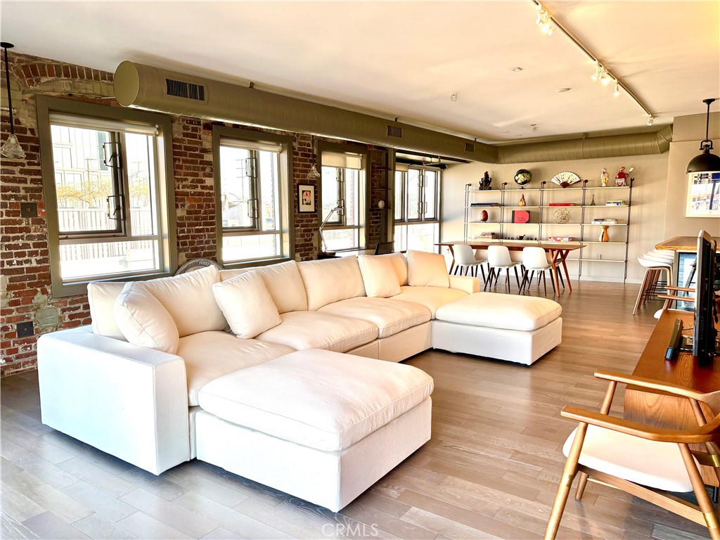 Experience urban sophistication in the historic Arts District of LA. This light-filled corner penthouse remodeled by Hughes Umbanhowar Architects blends industrial loft modernism with all the warmth and comforts of home. Barker Block is the standard of style in downtown LA living, and unit 401 is in its own class. This 1,710 square foot loft with 2 bedrooms and 2 full baths offers exposed brick, steel beams, 10-foot ceilings, pull-out pantry, and steam shower. The rooftop deck has cinematic city views and sunsets, a hot tub, pool, and barbecue. This pet-friendly building's amenities include 24-hour security, a gym, private parking, and common gardens with a fire pit. Step outside to experience what TimeOut Magazine crowned the coolest neighborhood in LA, with some of the city’s best restaurants, cafes, breweries, and shops at your doorstep.