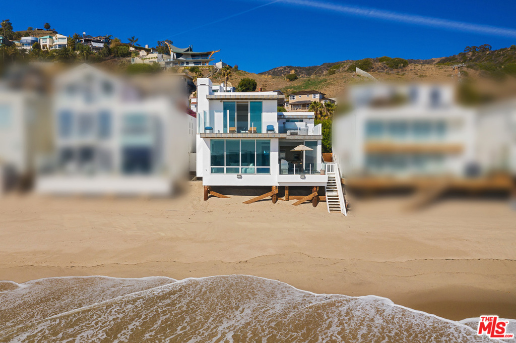 With its stunning views, desirable location, and striking contemporary design, this La Costa beach house is the perfect setting for the Malibu lifestyle. Wraparound windows and decks on two levels invite sunrise-to-sunset appreciation of the ocean's ever-changing panorama. Just inside the gated entry is a serene and very private walled garden with room for yoga or a quiet writing table. Through the front door, it's all about the view as stone tile floors, recessed lighting, and floor-to-ceiling glass emphasize clean lines, an open layout, and great indoor-outdoor flow. The living room, with a fireplace, adjoins a spacious dining area. Both open onto an oceanfront deck for barbecues and al fresco dining. The ocean-view kitchen is equipped with top-grade appliances, granite countertops, lots of built-in storage. There's also an ocean-view den/office/media room, full bath, and laundry room on the main floor. Three bedrooms upstairs include a sensational ocean-view owners suite, with wood floors, fireplace, spa-style stone-tiled bath, and two oceanfront balconies with hot tub and room for lounging and stargazing. Stairs to the beach, outdoor shower, two-garage with work station, and built-in cabinets and storage. Air-conditioned for year-round comfort, this lovely contemporary La Costa residence is perfect for casual beach living and lively entertaining.
