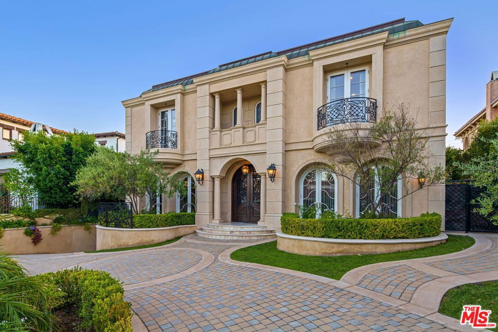Set within a highly coveted neighborhood near the Brentwood Country Club, this palatial estate pairs high-end interiors with an incomparable outdoor setting to revel in year-round California living. Through the foyer, an open-concept floor plan flows from the formal living room into the office, dining room and adjoining family room and gourmet chefs kitchen, awash in natural light via glass French doors. Just outside lies a true oasis, complete with a pool and spa, multiple lounge areas for entertaining, a fire pit, built-in BBQ and grassy lawn. Via a grand, spiral staircase, the top floor features 4 bedrooms, including the primary suite with spa bath, fireplace, balcony and ample closet space. The lower level consists of an en suite bedroom, cutting-edge movie theater, laundry room and wine cellar. Other features include an elevator and 5-car subterranean garage. Impressive in size yet comfortable in layout, this Brentwood retreat sets a new benchmark for deluxe luxury living.