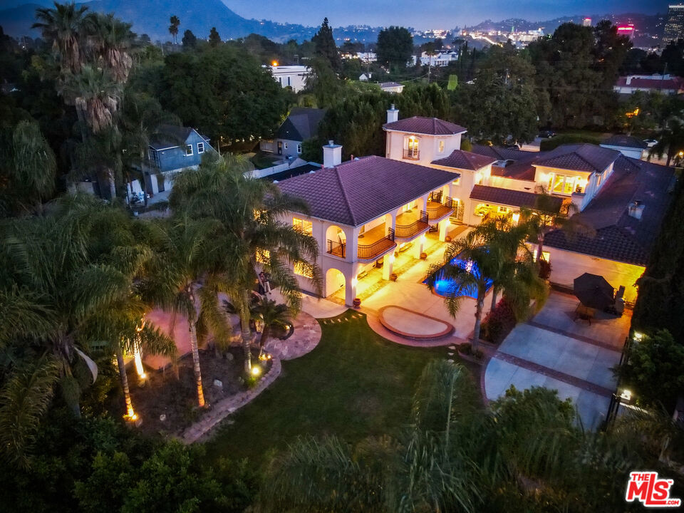EXQUISITE GATED HOME WITH TWO-STORY GUEST HOUSE IN TOLUCA LAKE! This Spanish-Mediterranean estate with Santa Barbara flair spans 8,500 sq ft (apx) with 8 beds/8 baths across multiple structures on an expansive, flat 3/4-acre (apx) lot. A fully contained two-story guest house overlooks the saltwater pool and gardens, each level with 2BR/1BA, its own kitchen, and laundry. Ideal for multi-gen living, creatives, or excellent income potential. The primary residence adds a dedicated office with a kitchenette and a turret room with a separate entrance, plus a gym, tucked-away movie theater, and a custom "catio" to keep your cat or dog safe. The gourmet kitchen features a granite island, top-tier stainless appliances, and custom maple cabinetry; the luxe primary suite offers dual oversized walk-ins, Italian marble vanities, and a spa-caliber bath with jetted tub. Resort-style grounds include multiple courtyards, an arched rose garden, an elevated gazebo, a soothing waterfall, and a Spanish-style saltwater pool/spa, with a freestanding pool house/bath for effortless entertaining. Practical upgrades: oversized garage with additional parking, seven fireplaces, copper plumbing, concrete Spanish tile roof, smooth ceilings, multiple HVAC units, water softener/filtration, indoor/outdoor surround sound, two large storage buildings, tankless water heaters, and Cat 5 wiring. Moments from studios, cafes, and village amenities, you don't want to miss this extraordinary one-of-a-kind compound. Check out our website for more videos, aerials, and 3D imaging! SELLER FINANCING CONSIDERED -- please inquire.