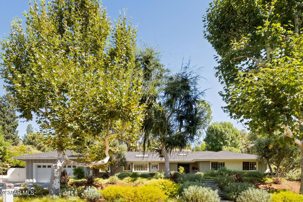 Welcome to this remarkable five-bedroom, four-bathroom California Ranch retreat, ideally located south of the Boulevard in Woodland Hills' coveted Vista De Oro neighborhood. Offering more than 3,200 square feet of timeless living space, the home is surrounded by mature trees and lush landscaping. A classic facade, double-door entry, and gracefully designed garden pathways create an inviting first impression. Inside, the design emphasizes comfort, flow, and enduring style. The primary suite is a one-of-a-kind retreat, blending luxury with warmth. A wall of library-style built-in bookshelves brings character, while an exquisite wood-and-marble fireplace serves as a striking focal point. Classic French doors open to the outdoors, creating a light-filled indoor-outdoor experience. Overhead, oversized skylights flood the space with natural light, making the suite an inspiring sanctuary. The retreat is complete with a walk-in closet featuring custom built-ins and a spa-like bathroom with a marble soaking tub, glass shower, and dual vanities. Three additional bedrooms share a hallway bathroom, while a large en-suite bedroom at the end of the hall enjoys its own private courtyard with views of the pool--ideal for guests or extended family. A convenient powder room is also located off the main hallway. Throughout the home, classic details shine: rustic wood floors, custom built-ins, multiple fireplaces, and abundant natural light. Skylights are thoughtfully placed, enhancing the bright and airy feel while highlighting the timeless finishes. The family room flows seamlessly into the formal living and dining areas, creating connected spaces ideal for entertaining or everyday living. For the wine enthusiast, a custom climate-controlled wine cellar offers floor-to-ceiling storage for a curated collection, while the adjoining wet bar provides an elegant space for serving beverages and cocktails and also added storage. Outdoors, the backyard is designed as an extension of the home. The expansive outdoor pavilion with a wood-burning fireplace overlooks the pool and spa, while a spacious lawn and decomposed granite area provide versatility for gatherings, outdoor dining, lawn games, or play. Mature trees and lush landscaping enhance the setting, with the sparkling pool and spa serving as the centerpiece for relaxation. This residence embodies classic California Ranch living with timeless quality--from its welcoming curb appeal to its light-filled interiors and resort-style grounds. It is a truly special property you won't want to miss.