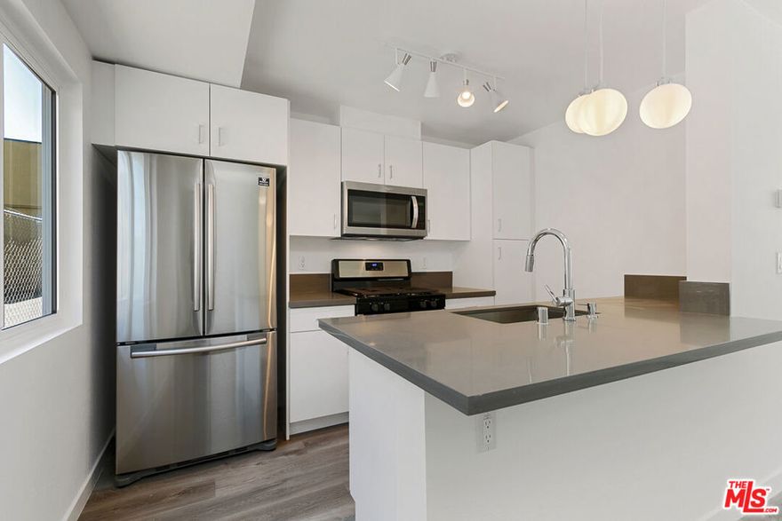 Updated Lake Balboa 1bed/1bath top floor w/ air & gated parking.     Top floor unit with hardwood flooring, updated stainless steel kitchen wit refrigerator, ice maker, stove/oven, built in microwave, dishwasher, breakfast island, tile bath with custom lighting.  Central air/heat, gated parking, community pool, pets okay.