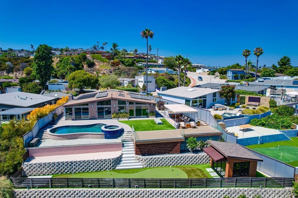 Pacific Beach Single-Story Zen Oasis with unmatched VIEWS! This 1,912 sq ft mid-century modern retreat blends custom design with serene indoor-outdoor SoCal living. The custom entry door opens to sweeping views of Mission Bay, the ocean, downtown, the magic of SeaWorld summer fireworks in the evenings. Featuring 3 bedrooms and 2 bathrooms, the home includes a luxurious primary suite with custom ensuite bathroom, walk-in closet, and new jacuzzi tub. Sustainable touches include solar panels, Tesla battery, and a 220-volt EV charger. The private backyard is a true resort: brand new expansive viewing deck, a gas-heated saltwater pool, jacuzzi, outdoor sauna, covered cabana, outdoor shower, gas fireplace, BBQ area with stone countertop and refrigerator, and a putting green with a detached golf shed, Zen meditation front yard anchored by a 6-ft Buddha statue. Property fully self maintained and yard/pool service included in rent. A seamless blend of style, comfort, and relaxation, this property delivers the ultimate San Diego lifestyle.