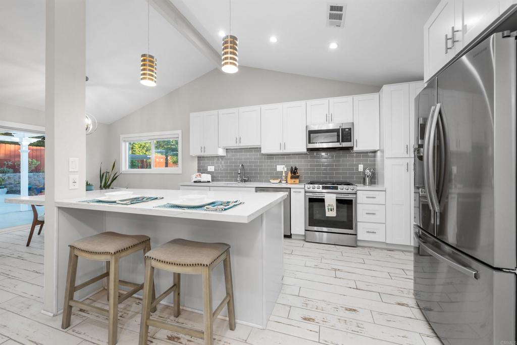 Tucked at the end of a quiet cul-de-sac, this beautifully remodeled home offers flexibility, style and a generous lot full of potential. Located on just over a quarter acre, it’s the kind of space that invites gathering, entertaining, and dreaming big. From the moment you step inside, you'll appreciate the vaulted ceilings, newer dual-pane windows with plantation shutters and open concept. The kitchen is the true heart of the home, featuring quartz countertops, a center island, soft close cabinetry, stainless steel appliances and room to spread out whether you’re hosting a crowd or enjoying a quiet dinner at home. The flexible layout includes dual primary suites, providing privacy and flexibility for guests, multi-generational living or even rental potential. The front suite includes a walk-in closet and an additional bedroom, making it a great setup for a home office, nursery, gym, creative space, additional walk-in closet for more storage or even a pet suite for your furry family members. The fully fenced backyard features space to spread out, entertain and enjoy the swim spa. The yard is easy with low-maintenance with drip irrigation throughout and fruit trees including avocado, fig, pear, apple, lemon, orange, tangerine, apricot and nectarine. And there's still plenty of space to add a pool, garden beds, play area, or possibly even an ADU - the options are almost endless to imagine whatever suits your lifestyle. Beyond the beauty and space, this home offers peace of mind, too. Major upgrades include a newer HVAC system with attic fan, roof, windows and doors, an updated electrical system and above-ground plumbing. Located just about a mile from Brengle Terrace Park and Moonlight Amphitheatre, this home is also conveniently close to Sprouts, Albertsons, and the popular restaurants and theaters in downtown Vista. With easy access to nearby 78 and 76 freeways, you'll be well-connected while still enjoying the peace and privacy of your own personal retreat. Updated and full of possibility, this is a home that can truly grow with you!