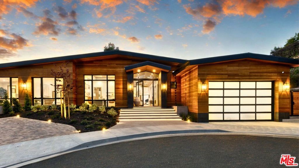 The Janice Place Estate is a contemporary masterpiece on a 28,950 square-foot lot oasis set within a secluded cul-de-sac just north of coveted Trousdale Estates. The newly built, 6194 square foot, single-story home boasts six en-suite bedrooms and nine bathrooms, surrounded by a lush and expansive backyard featuring an infinity pool and spa set over stunning canyon views. Past the sustainably harvested garapa wood facade with iron windows at the front exterior lies a 10-foot high, pitched oak ceiling entryway that leads to retractable floor-to-ceiling glass doors allowing the great room to seamlessly merge into the Eco-conscious backyard landscaping. The chef's kitchen features Meile appliances, Calacatta Borghini waterfall islands, custom-designed cabinetry and pantry, a full wet bar, and a glass-enclosed wine room. The media room sits beside a matchbook feature wall and easily converts from an expansive entertaining space or flows into an intimate home theater. Inside the spacious primary bedroom suite is a pearl onyx double-sided fireplace, his/hers baths; each with a sitting tub, steam shower, personal closet, and private patio. The five additional bedroom suites are perfect for family, guests, a private office, an indoor gym/yoga studio, or au-pair quarters. Outside is an entertainer's paradise with a custom barbecue station, multiple lounge areas, and a fire pit. This turnkey property is immediately ready with curated interior-designed furniture and a one of-a-kind art collection. Smart home technology, a Sonos sound system, and a camera security system complete this affluent lifestyle home.