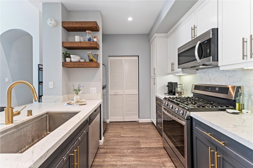 This beautifully remodeled top-floor penthouse offers luxury living in the highly sought-after Avenue One community. Featuring 2 bedrooms, 2 bathrooms, and a spacious loft, this stunning unit spans approximately 1,260 square feet with soaring 18-foot ceilings that flood the space with natural light. Enjoy peekaboo sunset views from your private patio—perfect for relaxing or entertaining. The home is loaded with upgrades, including a custom-designed kitchen with modern two-tone cabinetry, Caesarstone quartz countertops with a waterfall edge and energy-efficient LED lighting powered by a Lutron smart control system. The primary suite features an en-suite bath and walk-in closet, while the second bedroom offers direct access to the patio. Two side-by-side assigned parking spaces are included, along with access to Avenue One’s resort-style amenities: pool and spa, putting green, playground, BBQ area, fire pit, indoor basketball court, state-of-the-art fitness center, clubhouse, media lounge, and business conference center. Located just minutes from John Wayne Airport, UCI, Diamond Jamboree, premier dining, shopping, Fashion Island, and Newport Beach—this penthouse is your ideal luxury retreat.