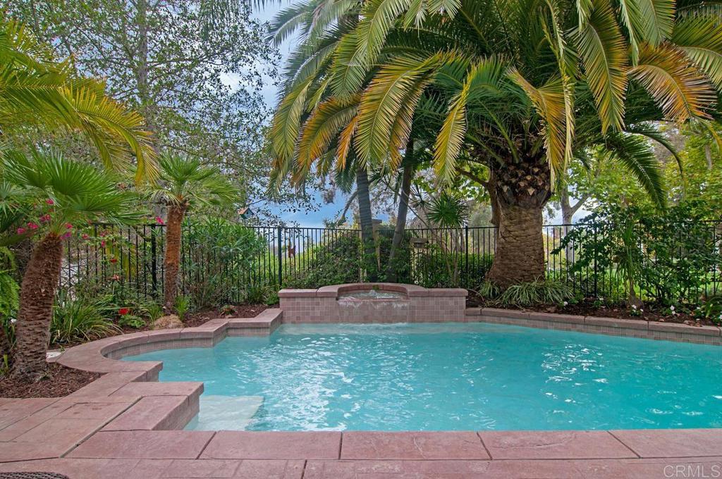 Enjoy the exquisite beauty & charm of this gorgeous executive home in Queensgate, a private highly sought after gated community of only 52 homes. Close to Lake Hodges, Westfield North County Mall, San Diego Zoo Safari Park, California Center for the Arts, restaurants, shopping, Palomar Medical Center, several golf courses, freeways & easy access to coast by way of Del Dios through prestigious Rancho Santa Fe. Queensgate is one of the best kept secrets in Escondido. City close but a very park like feel. As you make your way up the long driveway this beautiful home is set back from the street on an elevated lot & quiet cul-de-sac. Enter through the double doors into the light, bright living room with soaring ceilings, plantation shutters, rich travertine & wood floors, a formal dining room & spacious kitchen with granite countertops, stainless steel appliances, a large eating area looking into a huge family room with fireplace and French doors that look out to the sparkling pool and spa. The downstairs bedroom is currently being used as an office and has its own private full bath. One bedroom upstairs has a full private bath, the other two upstairs bedrooms share a full bath. The primary bedroom has a separate retreat that could be used as a sitting area, office, workout room or even a nursery. The balcony off the primary bedroom has incredible views & spectacular sunsets. A wonderful backyard for entertaining with mature trees, views of the beautiful mountains & one of the best locations in Queensgate, backing up to the lush, private community park. Great side yard with raised flower beds for gardening. Experience this home with a great location, beautiful floral gardens, tranquil scenery, peaceful atmosphere & open spaces. This is a must see home in a wonderful neighborhood.