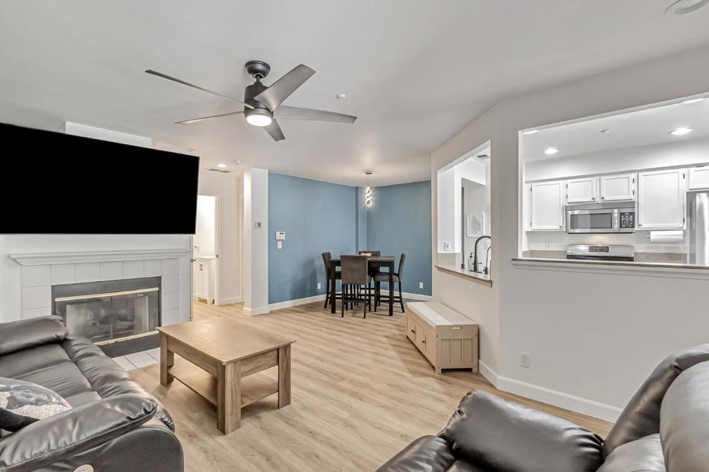 This townhouse-style condo features a bright kitchen with stainless steel appliances, granite countertops, a large sink with touch-sensor faucet (2023), recessed lighting, & sliding glass door (2023) that opens to a private patio. The kitchen flows into the dining area & living room, featuring a gas fireplace with mantle & ceiling fan. The vaulted-ceiling primary bedroom offers a ceiling fan & two mirrored closets with custom built-in dressers, shelving, & open storage space above them, along with an ensuite bathroom with dual sinks & a shower-over-tub. The second bedroom includes a ceiling fan & customized closet organizer. All three bathrooms feature updated vanities (2023), mirrors (2022), & toilets (2022). Upgrades include double-pane windows & blinds (2023), luxury vinyl plank flooring (2022), a Nest thermostat with ductwork improvements (2023), updated hardware, a dedicated laundry room, alarm system, electronic front door keypad, & a front screen door (2025). The attached garage features a new garage door (2023) & custom retractable screen (2023), plus an assigned parking space. Community amenities include a pool, basketball & volleyball courts, with Miyuki Dog Park & Kaiser Hospital nearby. Close to Cottle Light Rail Station & highways 85 & 101 for easy commuting.