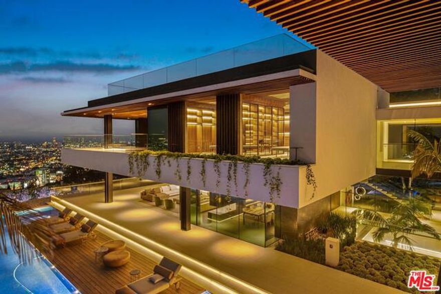 From world-renowned architectural design firm, Saota, this 20,000 sq. ft. estate is set on a promontory with unparalleled 300 degree city skyline views boasting unmatched design and exquisite bespoke finishes throughout. Automated glass sliding doors create a seamless confluence from the interior living spaces to plentiful outside seating and dining areas, including a 175-foot linear pool culminating in a waterfall cascading into an atrium garden. A 15-foot outdoor television rises from the ground with horizontal and vertical rotation, visible from every room in the house. Enormous entertainer's rooftop deck, state-of-the-art theater, curated wine cellar, glass elevator, unrivaled security and audio/visual integration, and a spa retreat replete with wet and dry sauna, cold and hot water plunge pools, and massage therapy. Private driveway leads to a multi-car garage. Unquestionably the most impressive property ever built above the Sunset Strip.