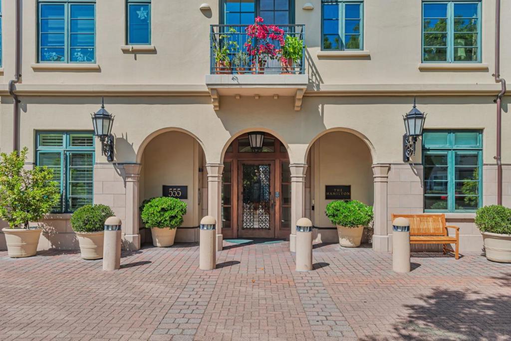 Discover refined living in this elegant 2-bedroom plus den/study, 2-bath ground-floor residence with easy access at The Hamilton, a premier 55+ community in downtown Palo Alto. Thoughtfully updated with brand-new flooring, fresh paint, energy-efficient LED lighting throughout, this home offers a bright and welcoming ambiance. Enjoy seamless indoor-outdoor living with private patio opening to a garden surrounded by patio walls, ideal for planting spring flowers or relaxing in serenity. The open-concept layout boasts high 10-foot ceilings with crown molding and abundant natural light. Additional bedroom and den/study provide flexibility for guests, a home office, or hobbies, while an in-unit laundry nook adds convenience. Opportunity for buyer to increase market value by turning den/study to full bedroom. The Hamilton elevates your lifestyle with exceptional amenities: a full-service dining room offering chef-prepared three-course meals nightly, a heated indoor pool, a jacuzzi, a spa-like fitness center, a library, and a 24/7 concierge. Nestled in vibrant downtown Palo Alto, enjoy top-tier dining at Tamarine or Ettan, coffee at Blue Bottle, boutique shopping on University Avenue, and classic films at the historic Stanford Theatre, a perfect blend of luxury and culture.