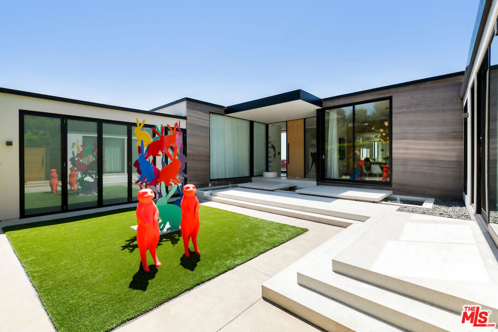 HANDS DOWN THE BEST DEAL IN TROUSDALE ESTATES. Contemporary masterpiece, designed by acclaimed architect Steve Hermann, situated on one of the most esteemed streets in Trousdale Estates. Discreetly concealed behind gates and mature landscaping is this 4,500 SqFt architectural, showcasing unparalleled design. Drenched in natural sunlight with seamless transition to the outdoors caters to an entertainer's dream while exuding absolute tranquility. The dramatic, glass pivot door is the prologue to the equally as impressive finishes throughout including the immense full wall of built-in's, custom track lighting, and Terrazzo flooring. Sleek Poliform kitchen boasts dual ovens and floating glossy-finished cabinetry capturing stunning views of the backyard with additional seating for al freso dining. Down the 12+ Ft high hallways is the palatial primary retreat worthy of its own private wing complete with a stone fireplace, glass enclosed changing area and opulent en-suite offering dual sinks, Antonio Lupi bathtub and generous rainfall shower. Enjoy the panoramic views of Trousdale while lounging on the expansive teakwood deck and swimming in the infinity edge pool. A Control4 smart home system, full server room, and automatic window treatments throughout are some of the many state-of-the-art features. A juxtaposition of sleek modern and warm textures create a harmonious blend of elevated luxury.