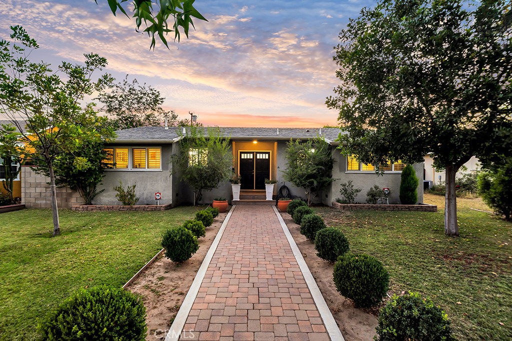Located in the heart of Granada Hills, this beautifully maintained, and move-in ready home offers timeless charm and exceptional value. Whether you're a first-time buyer, looking to downsize, or simply searching for a turnkey property in a desirable neighborhood, this opportunity is not to be missed! This inviting residence welcomes you with eye-catching curb appeal and a paver walkway that leads to classic double front doors. Inside, original refinished hardwood floors flow seamlessly through the sunlit living and dining areas, where large windows bathe the space in natural light and create an airy, welcoming ambiance. The spacious kitchen offers generous cabinet space and the convenience of an adjacent laundry area, smartly tucked at the end of the room with its own shelves and a wall of cabinets—ideal for additional pantry space or utility storage. With 3 bedrooms, 1 full bath, and 1 three-quarter bath across 1,275 sq ft, the layout is both functional and welcoming—enhanced by copper plumbing, central heat and air, recessed lighting, shutters and dual-pane energy-efficient windows—combining original character with modern comfort. The private backyard is warm and inviting, featuring a large covered patio ideal for al fresco dining or relaxing, a vibrant grassy lawn, and mature trees—including a beautiful jacaranda—that frame the space with natural beauty. With ample room for children to play, pets to roam, or simply to enjoy a peaceful morning coffee, the 7,199 sq ft lot offers both functionality and tranquility. The detached two-car garage—with its own alley access—is complemented by a separate sliding iron gate that also opens to the alley, providing additional access and excellent flexibility for RV or work vehicle parking. There's strong ADU potential, or even the possibility for multiple ADUs (buyer to verify). Whether you're dreaming of a cozy home to call your own or looking to expand your real estate portfolio, this property offers comfort, versatility, and exciting potential in a highly sought-after neighborhood.