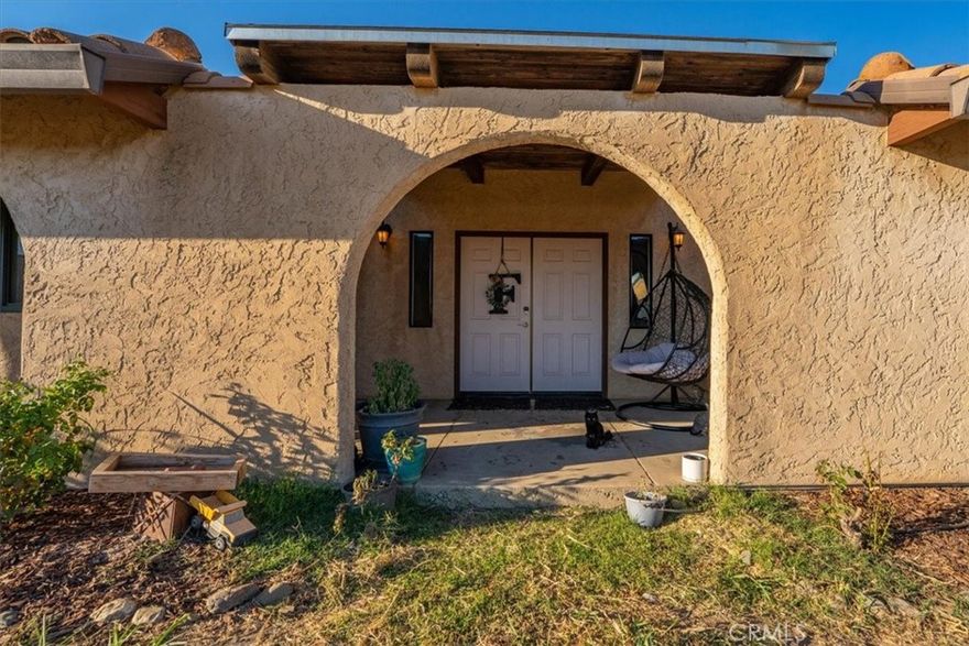 Spanish-Style Home on Almost 20 Acres! This charming Spanish-style home features classic arches, a tile roof, and a warm, inviting feel. The family room has beautiful exposed beam ceilings and a cozy wood stove—great for relaxing or gathering with friends and family. The large primary bedroom offers plenty of space and comfort. Outside, you’ll find just under 20 acres with room for animals, gardens, orchards, or whatever you can dream up. A variety of fruit trees including orange, lemon, lime, avocado, grapefruit, pear, pomegranate and persimmon already established. Owned solar and a Tesla battery add to the efficiency of this home as well as newer windows. Sale will include two 9.91 parcels. Whether you're looking for space to spread out or a peaceful place to call home, this property has a lot to offer.