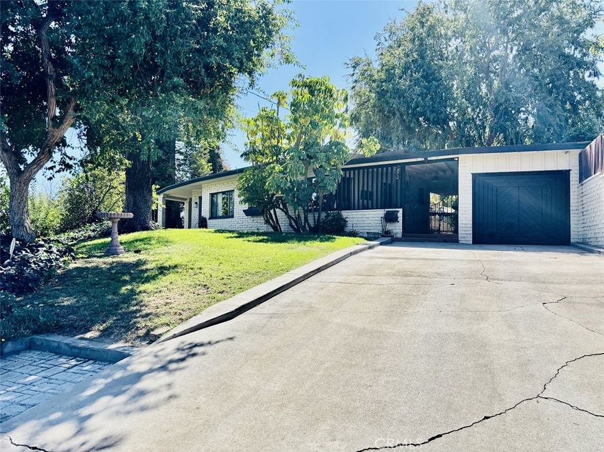 This is not today's cookie-cutter track home! It's a must-see, lovely home that is unique from the driveway to the rear yard to the exterior design and continuing into the interior. Although the interior offers updates that are tastefully blended with the original concept, thus keeping the Mid-Century vibe completely alive and beautifully on display, from the enormous windows that fill the interior with natural light to the exposed beams in the high ceiling, to the kitchen that boasts of that time. The home features a double-sided wood-burning fireplace in the living area that gives the relaxing ambient glow and the crackle of real wood. The spacious open floor plan offers three large bedrooms, two full bathrooms, a living room, and a dining room. The kitchen has ample storage space and a breakfast area that opens to the breezeway. The relaxing sunroom opens into the patio/courtyard, which is perfect for entertaining family and friends. The 2,163 SqFt home sits on a large 10,454 SqFT lot that has beautiful mature trees, including several fruit-producing trees.