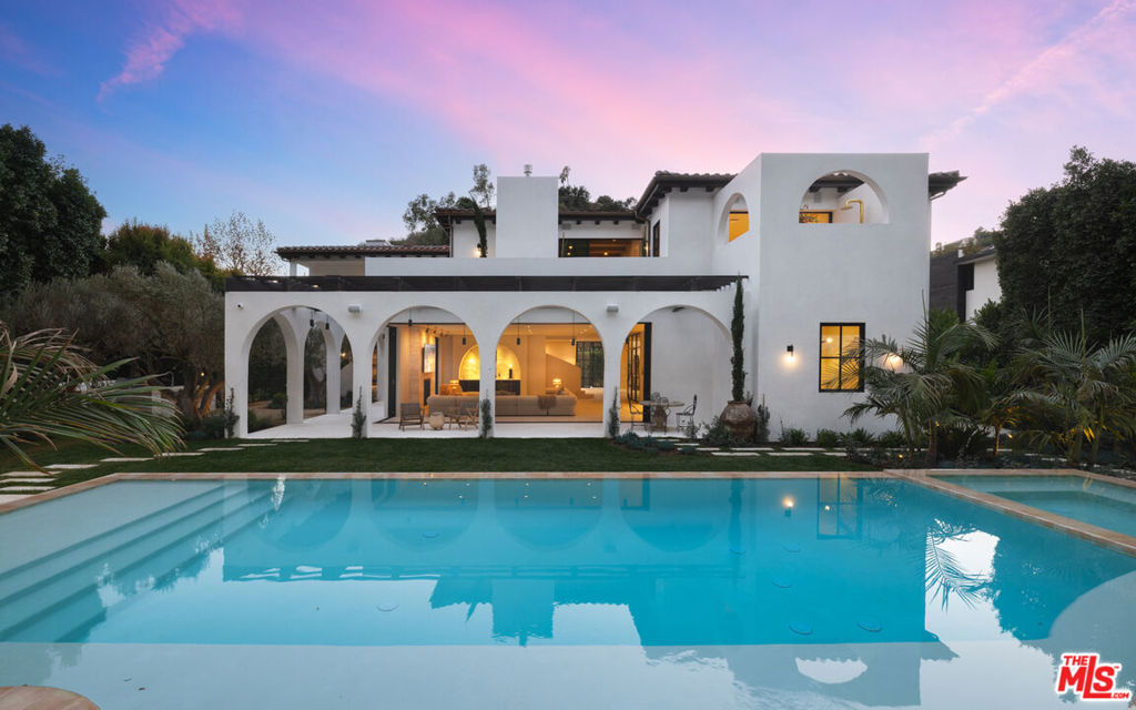 Positioned in the prestigious East Gate of the highly sought after lower Bel Air neighborhood near the iconic Hotel Bel-Air, this astonishing Spanish-Mediterranean estate seamlessly blends timeless elegance with modern sophistication. As you enter, double height glass & steel entry doors bathe the house with an abundance of natural light. Massive automated sliding door systems create the ultimate California lifestyle blurring the home's resort style exteriors with organic toned interior spaces. Adorned in custom Walnut millwork the gourmet kitchen is equipped with built-in Miele and Wolf appliances only missing a Chef's kiss. The entire home is complemented by select grade hardwood floors, handcrafted plaster walls, custom travertine stonework, and light fixtures by Apparatus and Allied Maker throughout.Featuring five luxurious bedrooms, an executive office, and a state-of-the-art theater, this home is designed for both elevated comfort and non-stop entertainment. Luxurious custom plumbing fixtures by Gessi and Graff add a spa-like touch to the primary bath, kitchen, bar & powder room. On the exterior you'll find limestone balconies, hardscaping, and a limestone-clad ADU with a roof deck that accentuate the outdoor living experience. Copper gutters, custom steel and aluminum windows and doors, and lush landscaping including 125-year-old olive trees and thousands of plants create a private, serene retreat. A three-car garage completes the offering, making this property the epitome of luxury living in one of Los Angeles' most coveted areas.
