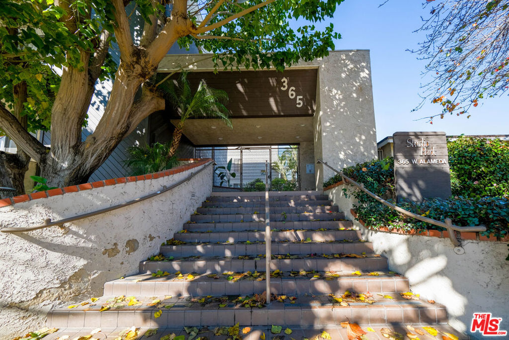 Welcome to this beautiful condo unit, perched on the top floor of the highly desirable Studio Park complex! Bathed in natural sunlight throughout the day, this home boasts expansive windows that fill the open-concept living and dining areas with warmth and light. Upon entry, you're greeted by a charming skylight and high ceilings, creating an airy, inviting atmosphere. The living room features a cozy fireplace and opens to a private balcony perfect for relaxing or entertaining. The updated kitchen includes granite countertops, recessed lighting, and a second skylight. This spacious unit offers two bedrooms, including a generous primary suite complete with a large en-suite bathroom and walk-in closet. Additional highlights include in-unit laundry, one shared wall for added privacy, and side-by-side parking. The building offers amenities: an outdoor patio, sauna, private shower and workout area, BBQ area, pool table, and a large recreation room ideal for hosting gatherings. Located in the heart of the Rancho neighborhood, you're just steps from Griffith Park, LAEC, trails, shops, restaurants, Universal Studios, Burbank Airport and highly rated schools including LILA and Burbank's Blue Ribbon schools. Ample guest street parking available. Don't miss this rare opportunity to own a top-floor gem in a prime location truly a place you'll love to call home!