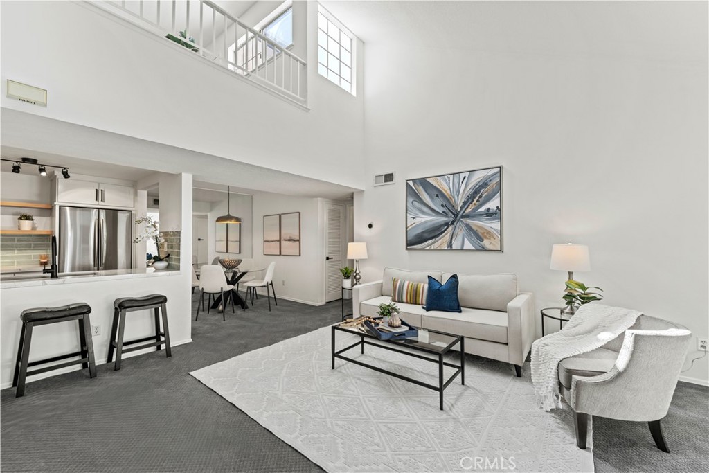 This move-in-ready condo is easily one of the NICEST units in the Siena Villas complex in Valencia! Boasting high ceilings and showing light and bright with nobody above you, pride of ownership is evident with several upgrades including an updated kitchen with quartz countertops, sage green subway tile backsplash, newer shaker style soft-close cabinetry tastefully accented with matte black hardware, stainless steel single-basin sink and appliances (fridge included), and natural wood floating shelves. Your living room features a cozy fireplace with a fireplace mantel and sliders for easy access to your private balcony overlooking the serene walking trails while enjoying the sights and sounds of nature. Your bathroom includes a spacious walk-in closet, two newer vanities with matching matte black hardware and fixtures, a sleek frosted-glass barn door separating the updated tiled shower with rainfall shower head and handheld shower sprayer, and a stackable washer and dryer unit in a dedicated laundry closet. Your bedroom boasts high ceilings and its own sliders for access to your private balcony. The upstairs loft/flex space is PERFECT for a home office, play room, workout room, craft room, media room, or anything your imagination can come up with! The HOA includes 3 pools/spas, a tennis court, car wash space, and covers sewer and trash. You have 2 dedicated garage spaces in an underground parking structure with dedicated storage as well. Located in one of the best parts of Valencia being close to lots of dining options, shopping centers, the Valencia Town Center Mall, parks, paseos, biking paths, and some of the most highly rated schools, come and make this your own while you still can!