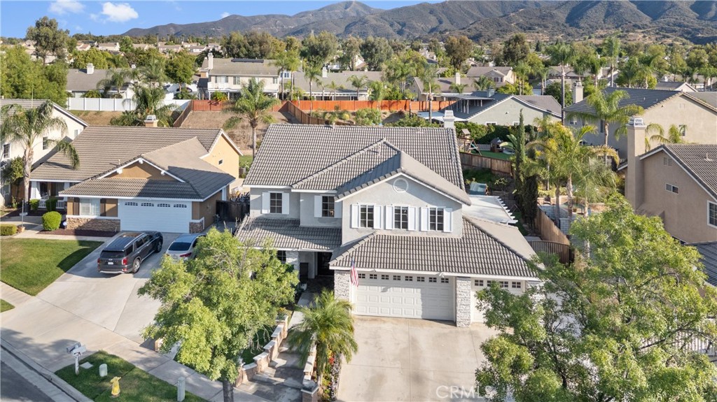 Welcome to your new home, a spacious and well-appointed home tucked inside a quiet cul-de-sac in a highly sought-after Mountain Gate neighborhood of Corona. This 4-bedroom + loft, 2.75-bathroom home offers a versatile layout with one bedroom and a full bath conveniently located on the main floor. The primary suite includes its own private bathroom and a walk-in closet, while all bathrooms have been recently remodeled with thoughtful finishes. Inside, you'll find high ceilings and an abundance of natural light, a beautifully updated kitchen that opens to the family room, plus a separate dining area and formal living room—ideal for both everyday living and entertaining. There's also an individual laundry room downstairs and direct access to a 3-car garage with extended RV parking. Out back, enjoy a built-on, permitted sunroom, a covered alumawood patio with lighting, and a built-in BBQ island under its own shaded cover. The large, private backyard also features an in-ground pool and spa—perfect for relaxing or entertaining year-round. Situated on a generous lot with no HOA and solar panels for energy efficiency, this home is within walking distance to top-rated schools, Mountain Gate Park, and local shopping and dining at Mountain Gate Marketplace.