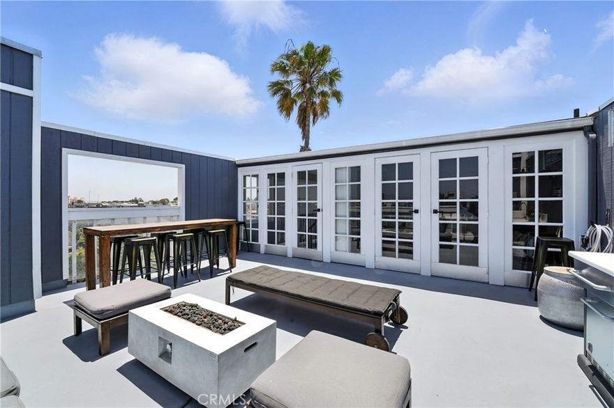 Stunning 4-level end-unit townhome located on the highly sought-after Marina del Rey Peninsula. This fully furnished and tastefully upgraded 3 bed, 2.5 bath residence offers an exceptional coastal lifestyle just moments from the sand.
The first level features two spacious bedrooms, a full bathroom, a powder room for guests, and a private balcony—ideal for relaxing or reading. The main level boasts an open-concept living space with soaring ceilings, a skylight with retractable blinds, a cozy fireplace, a custom wood accent wall, and abundant natural light. The upgraded kitchen includes stainless steel appliances and a seamless flow perfect for entertaining.
The third level loft includes an ensuite bathroom, ample closet space, and canal views. Step into the top level that offers a flexible space for an office, studio, or den, with direct access to an expansive rooftop deck. Enjoy outdoor living with a built-in kitchen, fire pit, patio seating, and views of the canal, mountains, and Hollywood sign.
Additional highlights include a private backyard with a jacuzzi, two subterranean parking spaces, personal storage and bicycle storage. This is a secure building with cameras. Located within close proximity to the iconic Venice Beach, the bike path, restaurants, and entertainment.

Enjoy the best of Marina del Rey coastal living in this one-of-a-kind, move-in-ready home.