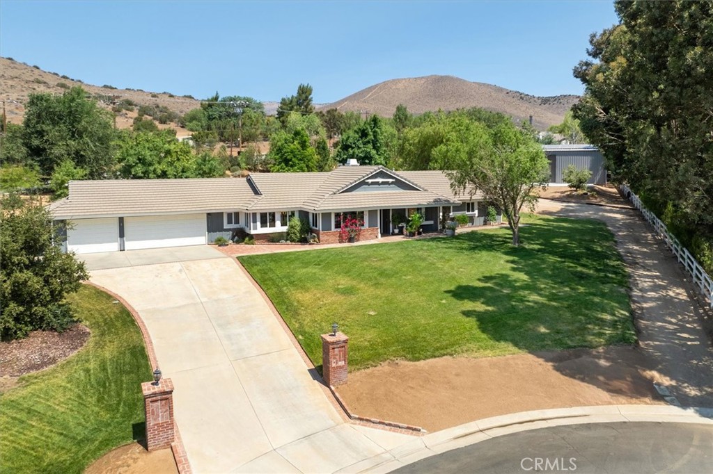 Welcome home! This beautiful ranch offers 4 bedrooms, 3 baths, 2260sqft home on over an acre of land. The interior has been nicely upgraded throughout with upgraded flooring, newer carpet, custom cabinets and countertops and stainless steel appliances. The open floor plan is perfect for entertaining and enjoying the views of the surrounding mountains. The show stopper is the endless list of added features. The property has a vineyard, greenhouse, above ground pool with deck, oversized jetted jacuzzi, horseshoe pit, 65 trees including 2 oak trees and a fruit orchard, garden house, and a massive 40ft x 60ft warehouse/workshop/RV Garage. The RV Garage is over 2400sqft with 2 huge 14ft x 14ft roll up doors. The entire garage is insulated and has 2 AC units to keep it cool. It has a second story mezzanine for storage and an added gym. Below is a laundry area, more storage, an office and a bathroom. To work on your toys there is a 10,000 pound car lift! The garage is wired with 50Amp for your RV and a dumping station. There is OWNED SOLAR (15KW) on the roof of the garage which powers the entire property and includes a 10KW backup for power storage. In addition there is a whole house backup generator so you are never without power. This property is one of a kind. Come see it!