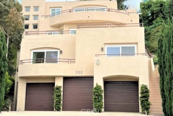 Enjoy the city and ocean views from this sophisticated, completely remodeled, contemporary condo. The new kitchen is appointed with sleek, modern finishes. Quartz counters, stainless steel appliances, a” Bosch gas range,” and Bosch dishwasher and microwave, a Samsung refrigerator, and a large, stainless farm sink. All are accented with a stylish backsplash. Bathrooms feature custom light fixtures and modern floating vanities. Ceiling fans in both bedrooms and the living room can be conveniently operated by remote control. Individual dimmer switches can control the dramatic lighting throughout this home. Laminate flooring throughout. LG "Smart System" washer and dryer in the laundry closet features built-in cabinetry. The peaceful location at the end of a serene cul-de-sac makes this property extremely desirable, with a large private one-car garage and additional parking in the driveway. The walk score of this location is 91. You can walk to Main Beach, restaurants, and grocery shopping at Whole Foods. On each Saturday, there is a Farmers Market 2 blocks away. The Sawdust Festival and Pageant of the Master, and Laguna Playhouse are nearby. Steps to nearby scenic, expansive, and beautiful hiking trails to keep you fit. This is a location where you can leave your car parked and enjoy all that the Laguna Beach lifestyle offers.