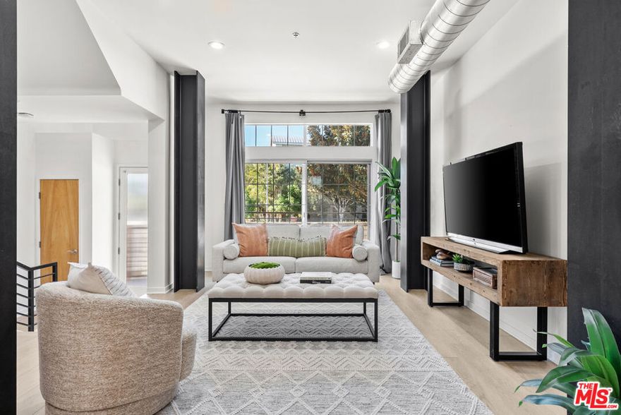 Beautifully refreshed and stylishly upgraded townhome in the coveted Bridgeway Mills community of Playa Vista. Step inside to an airy, open-concept living space with soaring ceilings and abundant natural light, where the industrial feel of exposed beams and ductwork meets a sleek, modern aesthetic. This home has been extensively updated, featuring brand-new flooring, fresh interior paint, refinished cabinetry, new LED lighting, and several new windows that enhance light and energy efficiency. Enter directly from your private, oversized 3-car garage or from the large front patio that creates a welcoming urban entry. The main level includes a spacious great room with flexible living and dining areas framed by front and rear windows, perfect for everyday living or entertaining. The kitchen is both functional and refined, offering stainless-steel appliances, stone countertops, and custom refinished cabinetry with ample storage. Continue upstairs to a large, bright loft with a private balcony that makes a perfect creative or office space, or could be easily enclosed to make a third bedroom.  The loft shares a full bathroom with a secondary bedroom on this level. The top-floor primary suite serves as a private retreat with vaulted ceilings, generous walk-in closet, and a spa-inspired bath featuring dual sinks, a soaking tub, and separate shower. Step out to the private 3rd floor deck with a cozy fireplace, ideal for morning coffee or evening relaxation under the coastal sky. Enjoy the exceptional Playa Vista lifestyle, including resort-style amenities such as fitness centers, pools, parks, sports courts, restaurants, Whole Foods, Runway retail, and proximity to Silicon Beach's leading employers, LAX, LMU, and the beach. This home is a perfect blend of sophistication, comfort, and convenience in one of Los Angeles' most dynamic communities.