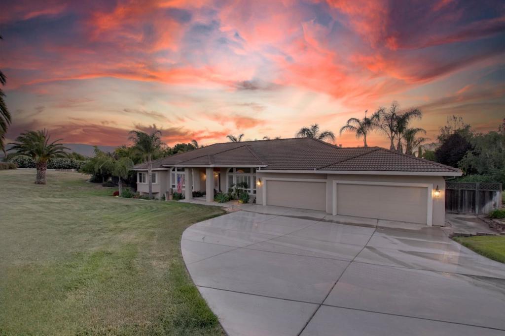 Welcome to this spacious 4-bedroom, 3-bathroom home located in Hollister. Offering a generous 2,870 sq ft of living space, this residence features a comfortable and functional layout perfect for everyday living and entertaining. The kitchen flows seamlessly into the family room, creating a warm and inviting space for family gatherings. A formal dining room provides the ideal setting for dinner parties and holiday meals. Stay comfortable year-round with central AC and ceiling fans throughout. The home showcases a beautiful mix of carpet, hardwood, and tile flooring, adding both style and comfort. Cozy up by the fireplace on chilly evenings. Step outside to your own backyard oasis, where over 30 mature palm trees create a resort-like setting around a sparkling swimming pool the perfect spot for entertaining guests or enjoying a peaceful sunset. The pool is equipped with solar heating for an extended swim season. The expansive 4-car garage offers plenty of room for vehicles, hobbies, or extra storage. The property also includes an owned solar power system to reduce utility costs and promote energy efficiency. This beautiful home is being sold fully furnished all furniture, the pool table, and wall hangings stay making it truly move-in ready. Enjoy space, comfort and relaxation.