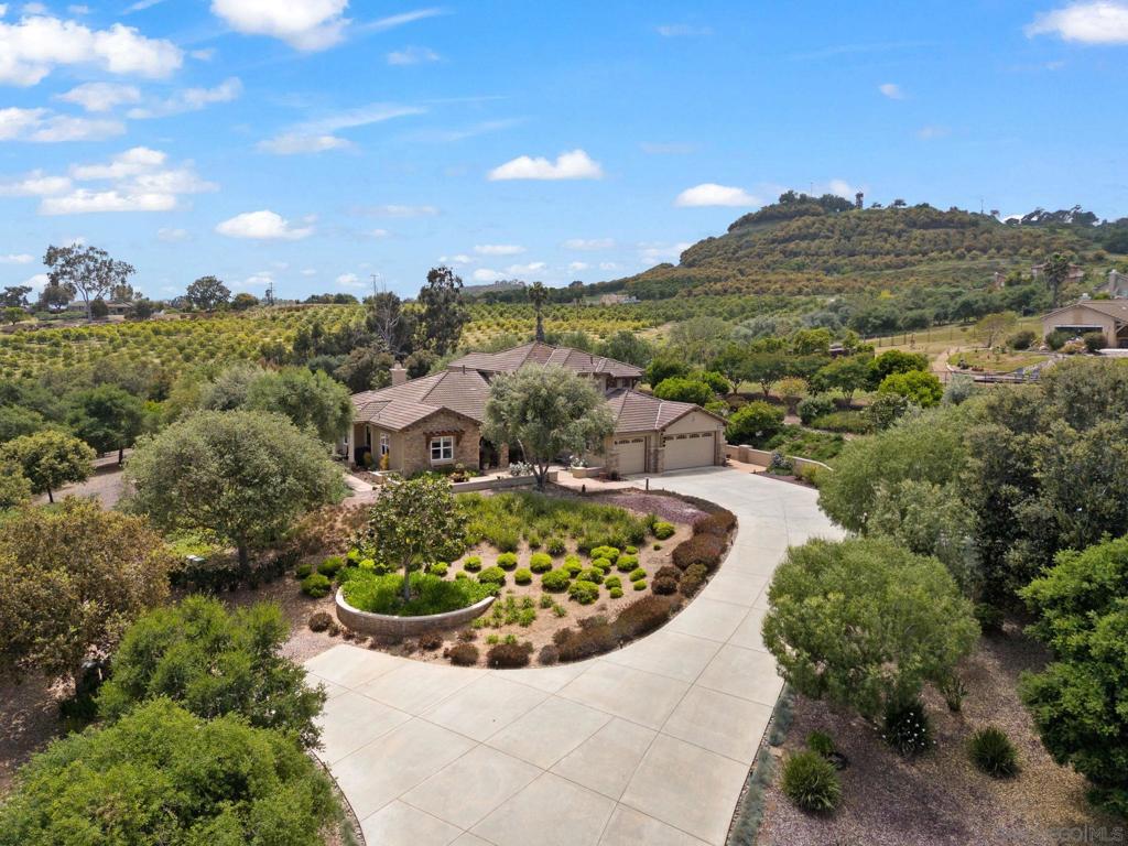 Welcome to 332 Lemonwood Drive, a sanctuary of elegance in the gated Hill Ranch community of Fallbrook, CA. Spanning 3,539 square feet, this residence offers sophisticated living on 2.15 sunlit acres, with potential for an ADU and pool. Inside, discover four bedrooms and three and a half bathrooms, adorned with fresh paint and new engineered hardwood floors. The chef’s kitchen, equipped with a Sub-Zero refrigerator, stainless steel appliances, and granite countertops, flows into a cozy family room with a gas fireplace and built-in sound system. The primary suite is a serene retreat with patio access and a built-in BBQ, complemented by retractable screens for seamless indoor-outdoor living. Upstairs, three additional bedrooms and an office nook offer flexibility for guests or working from home. Outside, enjoy lush landscaping with mature trees—including apricot, lemon, lime, orange, and avocado—that capture the essence of California living. A spacious driveway offers RV access, and a four-car garage provides ample storage.Experience refined living at 332 Lemonwood Drive, where every detail is designed for comfort and sophistication.