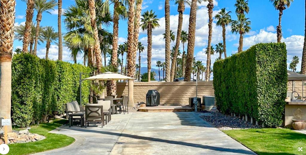 This beautiful luxury RV lot at Outdoor Resort Indio offers the perfect blend of comfort, privacy, and resort-style living. Located near the clubhouse yet tucked away against the resort entrance wall, the lot features a raised rear patio with pavers--ideal for entertaining or relaxing outdoors. Landscaping with extra palm trees and privacy hedges on both sides creates a serene, secluded atmosphere. Enjoy meals under the desert sky at a table with six chairs and two umbrellas, or fire up the BBQ for a perfect evening. The lot includes two convenient storage boxes, additional outdoor furniture, and a grassy pet area, making it both pet-friendly and practical. Whether you're looking for a personal retreat or an upscale home base for your RV lifestyle, this lot is a true gem.‍