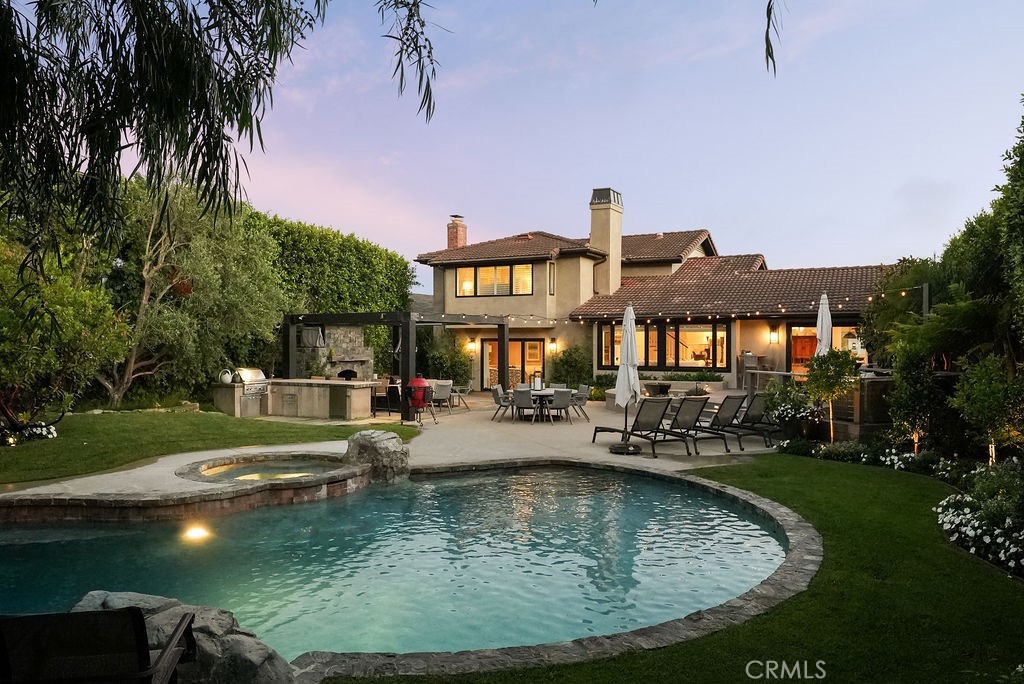 Nestled on a cul-de-sac in the coveted Harbor View Hills South community, 3808 Sandune is a rare sanctuary of timeless elegance and indoor-outdoor living. Perfectly situated just moments from CdM Village, pristine beaches, parks, and award-winning schools, this home presents the best of coastal Orange County in one of its most sought-after neighborhoods. Step inside to discover nearly 4,000 square feet of gorgeous living space, where soaring ceilings, expansive windows, and beautiful hardwood floors set an inviting, sunlit tone throughout. The versatile floor plan features 5 bedrooms—two of which are ensuite—including a downstairs bedroom for guests or a home office. Upstairs, the primary suite is a true retreat with an oversized bath, walk-in shower, separate soaking tub, and a boutique-inspired walk-in closet. Designed for effortless entertaining, the home boasts two generous living rooms (one offering a wet bar), a formal dining room, and a kitchen with abundant storage, high ceilings, a large center island, and a bay window with built-in seating. The backyard is an absolute showstopper—an expansive private oasis with impeccably landscaped grounds, multiple grass lawns, a sparkling pool and spa with a water feature, an outdoor kitchen, fireplace, and even a treehouse for endless fun. With nine distinct outdoor seating areas—including a charming front garden and deck spaces—the home is designed for unforgettable gatherings, al fresco dining, and moments of pure relaxation under the sun and stars. This is Corona del Mar living at its finest: refined, welcoming, and simply unforgettable.
