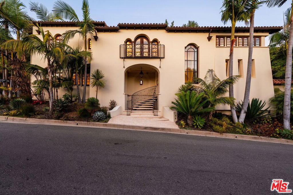 Nestled in one of Brentwood's most scenic enclaves, 746 Norway Lane is a Spanish-inspired villa that blends timeless charm with everyday functionality. A grand two-story foyer, highlighted by a sweeping wrought-iron staircase and expansive custom arched windows, sets the tone for this architectural gem. The thoughtfully designed floor plan showcases authentic details such as barrel and tray ceilings, iron details, exposed beams, arched passages, and thick plaster walls. The chef's kitchen is appointed with custom cabinetry and Viking appliances, opening seamlessly to the home's living and entertaining spaces. Upstairs, four generous bedrooms plus an office feature pitched ceilings and beautifully finished bathrooms, while the primary suite offers a serene retreat with private balconies overlooking the lush backyard. Refined finishes throughout include stone and marble surfaces, gold-leaf accents, antiqued mirrors, and rich walnut floors. The rear grounds provide an ideal setting for entertaining with resort-like amenities including lush landscaping, cascading waterfalls, a lagoon-style pool, built-in barbecue, and fire-pit. Impeccably maintained and move-in ready, this residence represents one of Brentwood's best offerings, located just minutes from the Brentwood Country Mart, the Getty, and the Westside's finest destinations, combining privacy, elegance, and convenience in a rare opportunity.