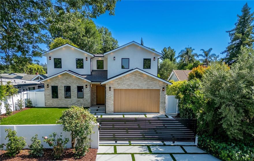 Privately Gated Estate in the Heart of Woodland Hills. Completed in June 2025, this property is a rare blend of luxury, privacy---crafted with designer finishes, and sleek, modern materials throughout both the main residence and the legally permitted ADU (with its own address). Step inside the stunning main house to discover 9'10" high ceilings, surround sound speakers, designer lighting, solid oak doors, Roman stone accents and wooden flooring. The chef's kitchen features top-of-the-line Thermador appliances, porcelain countertops, wine closet, immense pantry and other thoughtful storage solutions. With an open floor plan, the kitchen flows seamlessly into the living room (with its gas fireplace), and the dining that opens to the interior patio. Every modern upgrade has been considered: dual hv/ac systems with separate thermostats, solar panels, tankless water heater, EV wiring, new electrical & plumbing throughout. The oversized primary suite is a true retreat, featuring a private balcony overlooking the backyard, a cozy gas fireplace, a massive walk-in closet, and a spa-inspired bathroom complete with soaking tub and a luxurious dual-entry shower. All four bedrooms are ensuite; and the ADU offers an additional 2 bedrooms, 2 bathrooms, living room with electric fireplace, full kitchen and in-unit laundry. Step outside to enjoy the landscaped backyard--featuring a sprawling lawn, brand-new pool and spa, a fire pit, and a built-in outdoor kitchen. Nestled in a family-friendly neighborhood just moments from premier shopping and dining at The Village, Westfield Topanga, and Calabasas Commons; and zoned for top-rated El Camino Real and Hale Charter Schools.