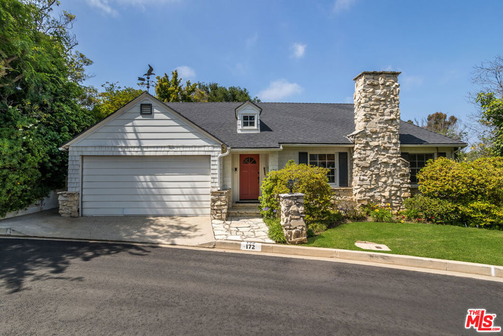 Tucked away on a Brentwood cul de sac, this charming property oozes curb appeal with its clapboard facade, stone chimney, dormered roof, and iron weathervane. The 2500+ sqft interior features a foyer, formal living room with fireplace and crown moldings, airy open concept dining/family room with beautiful treetop views, and kitchen with stainless appliances and breakfast bar. Two bedrooms with jack-and-jill bath, laundry room, powder room, and 2-car garage complete the main level. The lower level is devoted to a large primary suite with a huge ensuite bath. The lush, terraced yard offers charming brick pathways leading to multiple spaces for entertaining, relaxing and reflection under a canopy of mature trees, bougainvillea vines, and dappled sunlight. The 10,000+ sqft street-to-street lot offers the potential for an ADU with separate street access. Move right in or update this charming residence to make it your own in a neighborhood of $6,000,000-$10,000,000 homes. Kenter Canyon Charter Elementary School district.