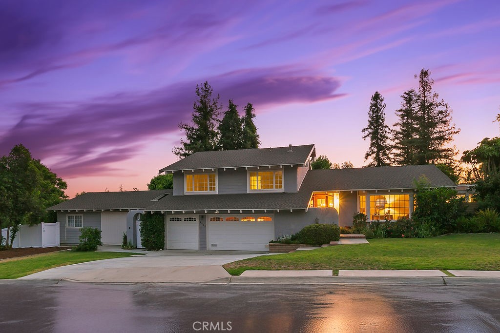 Nestled in the quiet and tranquil hills of Villa Park, this sprawling estate is full of the charm and character that defines the city in which it resides. This elegant example of the Americana dream has all the features you’d expect of a home built in an era where family and tradition was the goal. Arrive to a home with huge frontage and commanding curb appeal with rolling lawns, mature trees, and crisp architectural lines. Enter through hand crafted side lit and glass inlaid front door into foyer with soaring ceilings, brick finished flooring, and exposed beams and posts creating a warm and inviting feel. The living room is light and bright with cathedral ceilings and exposed T and G wood beam ceiling details. French doors to the spacious side yard give this room a light and airy ambiance. The dining room is perfect for those special holidays and gatherings with plenty of room for 8 person dining set. The custom-built kitchen has a cozy country charm, with handcrafted cabinets, large center island, stainless steel appliances, generous dining nook, farmhouse sink, glass-inlaid upper, and elegant brick and tile inlaid hood and splash design. Skylights flood the space with natural light, while French windows offer lovely views of the sparkling pool and yard. The family room has all the characteristics for nostalgic cozy nights! An expansive brick fireplace with oversized bricks and custom firewood box gives this room a homey feeling. The family room is also appointed with w/ wood floors, built in cabinets, and oversized windows w/ views of the backyard. The spacious primary bedroom features wood floors, a walk-in closet, and custom built-ins. The primary bath includes an elegant vanity, walk-in tub, and separate vanity desk. The secondary bedrooms are generous in size with fresh carpet, newly painted walls, & large French windows. Step outside to a parklike backyard, one of Villa Park’s signature features. Enjoy rolling lawns, a huge pool and spa, fruit trees, new vinyl fencing, built-in stainless-steel BBQ with ample counter space, mature landscaping, a detached utility room currently used as a classroom, an antique potting shed, and unmatched space and privacy. The raised planter beds, vintage greenhouse, and mature fruit trees are ready to be enjoyed and nurtured once again, just as they have been for decades. Other features include spacious bedrooms, dual vanity secondary bath, excellent location, separate outdoor entertainment areas, skylights, & more!
