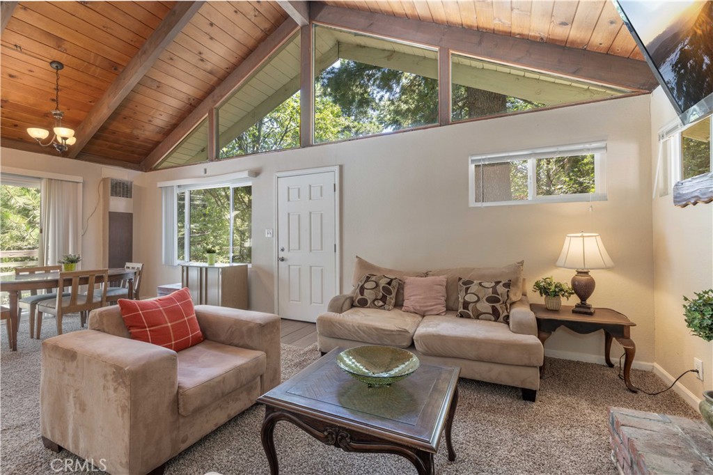 Less than 2 hours away from the hustle of LA, this Lake Arrowhead cabin is the perfect cozy retreat! Located in the prestigious Arrowhead Villas, this 2 bedroom, 1.5 bathroom cabin is full of rustic charm. Breathe in the fresh mountain air, while you relax on one of the two deck spaces surrounded by mature trees. Beautiful vaulted ceilings and lots of natural light throughout, as well as newly installed windows (2023). The spacious eat-in kitchen features ample counter space, while the large dining area provides more seating for larger gatherings. The main bedroom with en-suite powder room as well as a full bathroom are located on the entry level, and the second bedroom is located downstairs. Enjoy the added convenience of a full laundry and storage room, which can also be used as a home office. Take advantage of the recently installed roof (2023), adding value and durability to the home. The possibilities for this cabin are endless, whether you are looking for a primary residence, 2nd home for weekend getaways, or rental income. Easy access to Rim of the World HWY and other mountain communities, shopping, and restaurants.