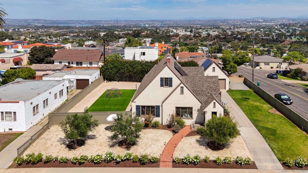 Welcome to this rare Ocean Beach gem—a 1927 Tudor/Normandy-style home that has only had three owners in nearly a century. Lovingly updated throughout, the home features high-end finishes, custom designer details, LVP flooring, picture windows, and full smart-home wiring. The property has been approved for the coveted Quieter Home Program and is set to receive brand-new windows and central A/C at no cost next summer. Best of all, it qualifies for the Mills Act, offering substantial property tax savings for historic homes. Situated on a double lot totaling 12,000 sq. ft., the grounds are a true retreat. The fully fenced backyard is designed for peace of mind with kids and pets, and includes pet-friendly turf, decomposed granite, 30 flourishing rose bushes, three mature olive trees, cypress hedges for privacy, and a nearly 60-foot honeysuckle vine that creates a lush garden atmosphere. A detached two-car garage with an EV fast charger and two additional driveway spaces provide excellent parking. Owned solar adds efficiency and long-term savings. Future expansion potential is unmatched, with stamped plans to convert the attic into a 915 sq. ft. primary suite and approved plans for an ADU in the backyard. This one-of-a-kind property blends timeless architectural character with thoughtful modern upgrades, all on a rare oversized lot in one of San Diego’s most desirable coastal neighborhoods.