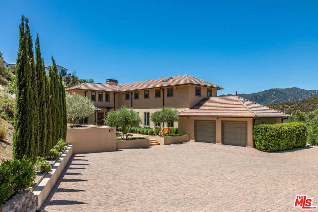This spectacular Mediterranean home surrounded by the Santa Monica Mountains is perched on 2.8 acres and is located on an exclusive gated street in Monte Nido with only two other luxurious estates. This magical neighborhood is a hidden gem with a small-town feel, community events and friendly atmosphere. Perfectly situated near Malibu State Park, Back Bone Trail and minutes to Malibu beaches, Calabasas shops and dining, and the 101. Here, you will enjoy nature, mountain views for miles, breathtaking sunsets, soaring hawks, mornings with a sea of clouds pouring in over the mountain-tops and the trickle of a seasonal stream. The property features a heated swimming pool and hot tub, view terrace, mature trees including oaks, California sycamores, orange and plum. A beautifully landscaped courtyard welcomes you in with a fountain and fishpond. The doors open to high ceilings with dazzling Murano hand blown glass lights and soothing light hard skived white oak hardwood floors. An inviting living room offers a peaceful seating area for relaxing and enjoying the mountain views with glass doors opening to a large terrace with seating and dining areas. Inside offers an elegant dining room with windows to the views and stunning hand blown light fixtures reminiscent of the convergence of sky and ocean in Venice. A light and bright kitchen overlooks the mountains and terrace with BBQ, and features an island, Thermador appliances, and is open to a seating area with surround sound television. Retreat to the first floor primary suite with views of the sparkling pool and hot tub. The spa-like bathroom offers a separate tub, shower, and walk-in closet. A sizable second bedroom/office and full bathroom is also on the first floor. Upstairs you will find three additional guest bedrooms all with spectacular views and two full bathrooms, as well as the laundry room and bonus storage room. The home has been meticulously upgraded with Carlisle wide-plank solid oak hand-skived hardwood floors, new Lennox Signature HVAC system, Farrow and Ball Paint through-out, new AV system with TVs, speakers and control system, new pool equipment and cover, wine refrigerator, Wilson Repeaters, whole house water filter, tankless heater and the list goes on! Two car attached garage and central vac. Within the award winning Las Virgenes School system and close to Viewpoint and Muse private schools, and Pepperdine University.
