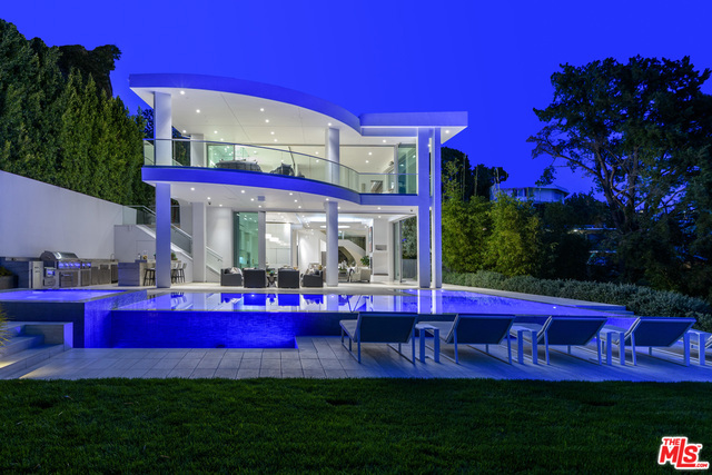 Situated above Sunset Blvd on a quiet cul-de-sac: an astonishing 6 bed, 8 bath, modern home lined with breathtaking city views. Enter through the gated driveway to find the sprawling 12,000+ sqft 3 story showplace. The home features a 2500sqft living room, large chef's kitchen w/ oversized island & butler's pantry, & it's own wellness center/ salon. Retire to the massive master suite w/ an office, 2 walk-in closets, & infinity bath tub. Entertain by the 30,000-gallon infinity pool, outdoor kitchen, theater, & Tuscan olive garden, all while taking in the endless views from atop the Hollywood Hills.