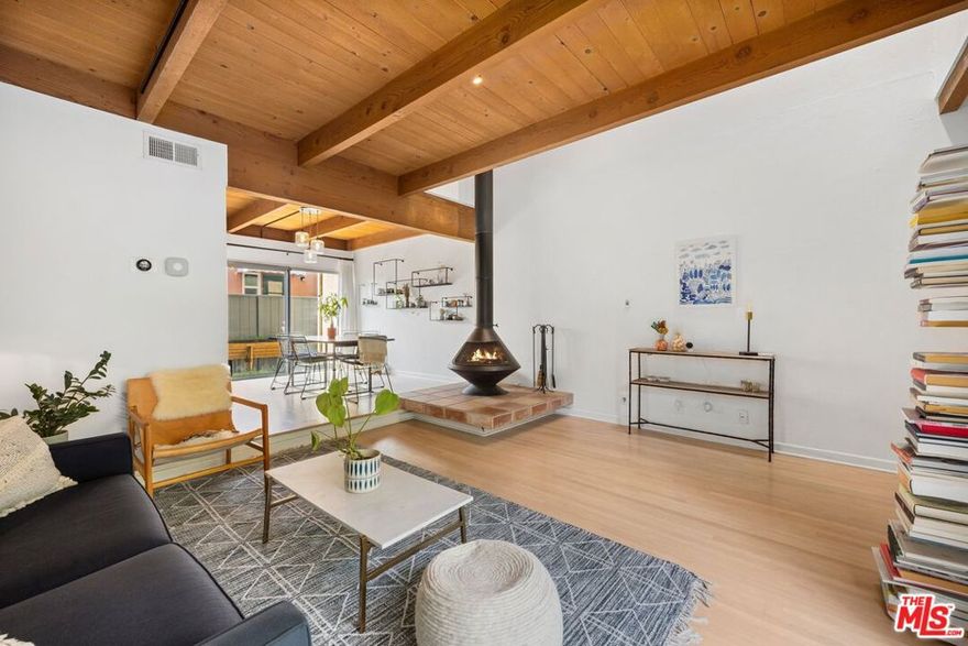 Don't miss this rare opportunity to own a stylish two-level townhouse-style condo in one of Santa Monica's most sought-after neighborhoods. The bright and inviting entryway features soaring open-beam ceilings and a skylight that floods the space with natural light. Enjoy a recently remodeled kitchen equipped with stainless steel appliances, quartz countertops, a pantry with roll-out shelves, and durable porcelain tile flooring. The spacious living room is anchored by a sleek mid-century modern fireplace, adding warmth and character to the home. Step outside to two private enclosed patios the larger one is outfitted with overhead lighting and ample seating, perfect for al fresco dining or entertaining guests. Additional highlights include custom oak flooring, recessed and studio track lighting, ceiling fans, an in-unit washer/dryer, NEST thermostat, and low HOA dues that include earthquake insurance. The secure building offers one assigned garage parking space and a bonus storage container. Tucked away on a quiet street, yet just minutes from the Expo Line, downtown Santa Monica, cafes, and restaurants.