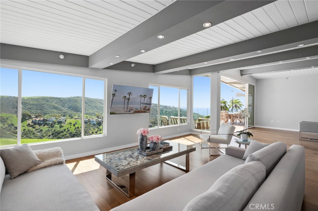 Discover coastal luxury at its finest with this stunning 5 bedroom, 4.5 bathroom contemporary residence in Laguna Beach. This breathtaking home seamlessly combines luxury with modern design, offering sweeping canyon and ocean views. Spanning 3,589 square feet, this architectural masterpiece blends indoor-outdoor living with elegance. Step through the grand foyer, illuminated by natural light, into an open-concept main level. Upon entry, you’re greeted by stunning Brazilian Walnut hardwood floors and high beamed ceilings creating an inviting ambiance. The gourmet kitchen is a chef’s dream featuring Caesarstone Quartz countertops, a commercial-grade gas stove and a Viking refrigerator.
The main floor is home to the luxurious primary suite with its own private balcony, oversized walk-in closet, and a spa-like 5-piece ensuite bathroom. Two additional guest bedrooms and a full bath complete the main level, while the open living and dining areas are perfect for entertaining. Expansive glass sliders frame breathtaking vistas and ocean breezes into the main level.
Downstairs, you’ll find two bedrooms complete with ensuite bathrooms and walk-in closets. Additionally, there is a versatile space that could serve as an office, gym, or additional living room. This level leads to a flat backyard designed for outdoor entertaining. The property also features a multi-car circular driveway with space for 5 additional cars and a two-car garage with direct access for added convenience.
With its unmatched style, stunning views, and ideal location, this Laguna Beach gem offers the ultimate coastal lifestyle. Located just minutes from Laguna Beach’s pristine coastline, world-class dining, shopping, and entertainment, this home offers the perfect blend of tranquility and accessibility.