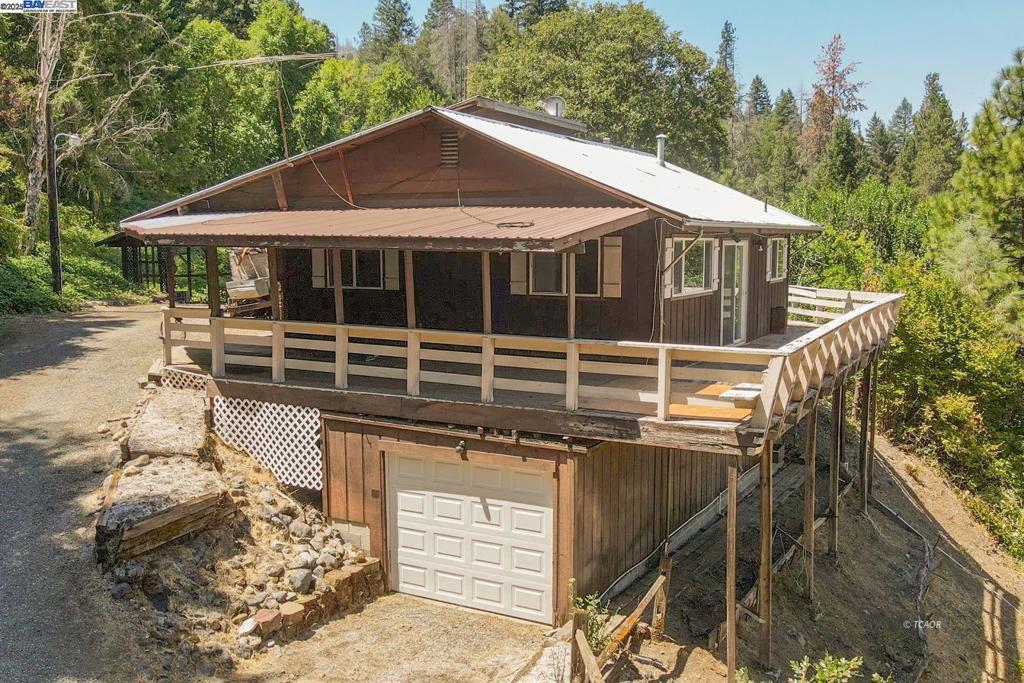 Nestled on 2.09 acres along a peaceful and charming country road, this 1,600 sq. ft. split-level home, built in 1974, offers comfort, updates, and beautiful surroundings. Featuring 3 bedrooms and 2.5 bathrooms, the home has all new flooring throughout. The primary suite boasts a walk-in closet, private slider to the deck, and a serene retreat feel. The kitchen and dining area also open to the massive wraparound decking-perfect for entertaining or soaking in the panoramic views. The lower level includes a full bathroom, laundry area, and a one-car garage for convenience. Outdoors, enjoy a large, fenced-in lower yard with sweeping views, plus an upper yard complete with water tanks and lush gardening areas. This property blends privacy, nature, and charm in one inviting package-ready for you to call home.