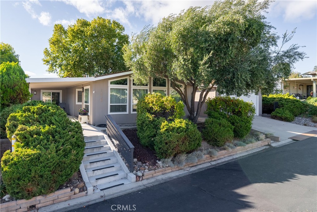 Welcome to 1320 Teal Avenue, a stunning and sophisticated home located in the Quail Run community of Paso Robles — a 55+ neighborhood! Set on a spacious 7,000+/- sqft lot, this beautifully updated manufactured home features 2 bedrooms, 2 bathrooms, and 1,856+/- sqft of thoughtfully designed living space. Step inside the family room filled with natural light from a multitude of windows and soaring cathedral ceilings accented by exposed wood beams. The layout flows into an informal dining area, and a well-appointed kitchen. The kitchen boasts soft-close cabinetry, designer solid-surface countertops, a walk-in pantry, and a stainless-steel appliance package for those who love to cook and entertain. Overlooking the kitchen is a welcoming living room with a sliding glass door that opens to the front porch for relaxing and enjoying your morning coffee. A charming foyer area leads to the backyard, while the home’s layout offers two private primary suites, each with its own bathroom. The indoor laundry room includes direct access to one of the bedroom suite’s walk-in closets for added convenience. Throughout the home, custom-milled siding and trim lend a touch of craftsmanship and sophistication. The outdoor spaces are equally impressive. The expansive lot features a brick patio shaded by a mature elm tree, garden beds, and a serene atmosphere that creates a retreat-like setting. The side yard includes a shed equipped with cabinetry and a sink for additional storage or workspace. Completing this beautiful property is a detached 2-car garage. Residents of Quail Run may enjoy access to a host of amenities just across the street, including a clubhouse, pool, spa, tennis courts, shuffleboard, and horseshoe pits, plus designated RV parking for those in need. With modern upgrades, elegant design, and a vibrant community setting, 1320 Teal Avenue embraces the charm of Paso Robles Living.