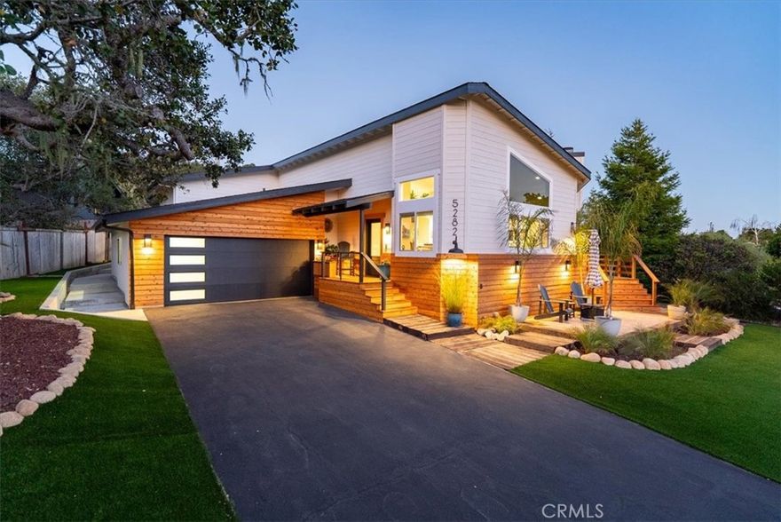 Discover this beautifully renovated 2,389± sq. ft. home in the highly sought-after Pine Knolls Estates neighborhood of Cambria, offering 3 bedrooms, 2.5 bathrooms, a bonus room, and an attached oversized 2-car garage. Fresh cedar siding pairs with modern interior finishes to create a one-of-a-kind residence designed for seamless indoor-outdoor living.

The great room welcomes you with soaring ceilings and panoramic glass rising nearly 12 feet, framing wooded coastal views and filling the space with natural light. A cozy fireplace sets the tone for gatherings, while crown molding adds refinement throughout. At the heart of the home is an expansive open-concept “working kitchen,” newly equipped with custom cabinetry, dual fuel range, and appliances selected for the owner, a classically trained chef. Skylights illuminate hand-selected Blue Tempest quartzite counters, generous prep areas, and custom Boos Block workstations. A front-row seating bar invites friends and family to gather while meals are prepared, and French doors extend to the courtyard lounge—perfect for entertaining and outdoor cooking.

The primary suite offers elevated ceilings, its own fireplace, and serene wooded views. The spa-inspired bath includes a custom shower with multiple Hansgrohe showerheads, a soaking tub, and a dual sink vanity handcrafted from reclaimed wood. French doors open to the private courtyard deck, where a swim spa provides the ultimate space to relax. Two additional bedrooms and a bonus room/office add flexibility for family, guests, or work needs.

Outdoor living has been elevated with four custom decks, a stone and reclaimed railroad tie patio, and thoughtful landscaping. Low-maintenance plantings, turf grass, bocce ball court, and tranquil tree views combine to create a true retreat.

Blending striking design, chef-driven detail, and inviting outdoor spaces, this Cambria property embodies the best of Central Coast living.